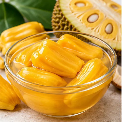 Yellow jackfruit pods in syrup in a glass bowl